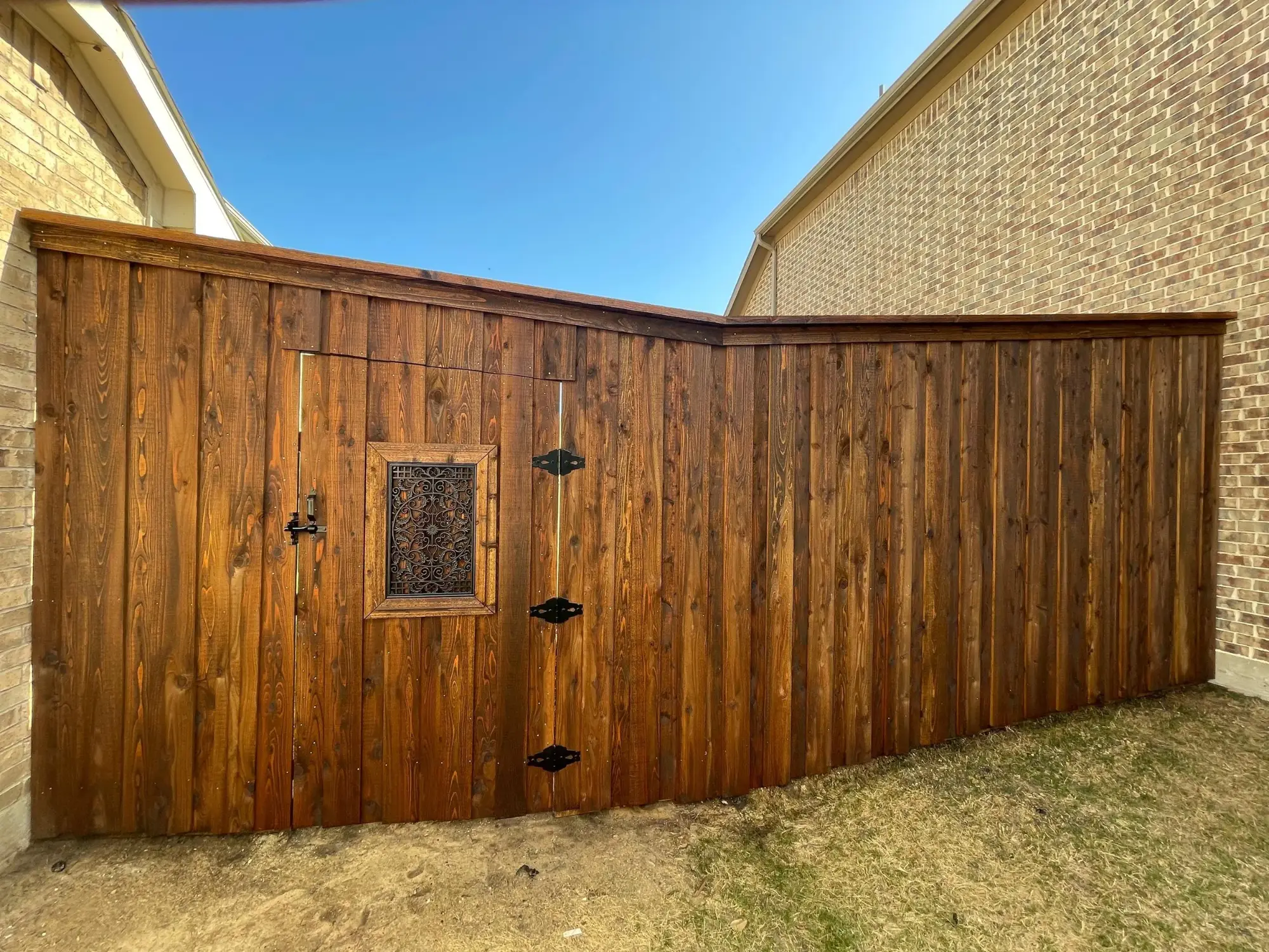 Recent project — dark-stained board-on-board fence with decorative gate